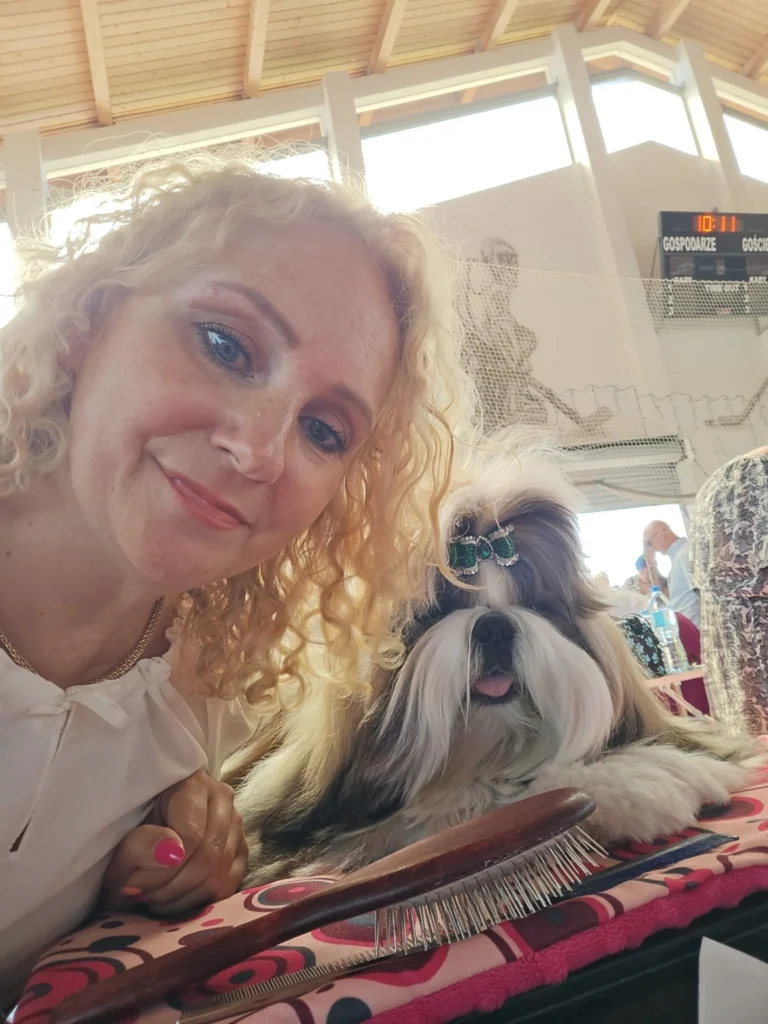 Opiekunka obok Shih Tzu na stole pielęgnacyjnym